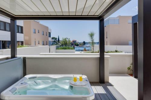 a hot tub on a balcony with a view at Shell Luxury Residences with Pool and Whirlpool in Zadar