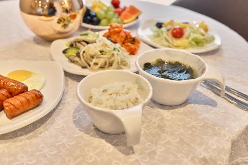 a table with plates of food and bowls of food at H Avenue Gwanganri Beach in Busan