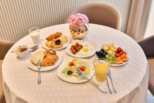 a table with plates of breakfast food on it at H Avenue Gwanganri Beach in Busan