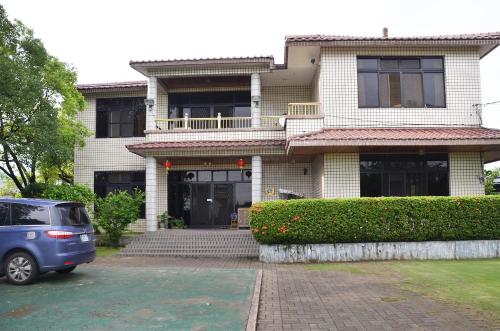 a blue car parked in front of a house at Kaohsiung Meinong Rabbit Paul Homestay B&B in Meinong
