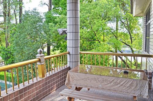 a wooden bench sitting on a porch with a fence at Kaohsiung Meinong Rabbit Paul Homestay B&B in Meinong