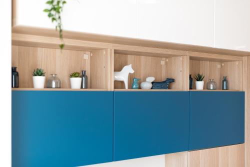 a wooden cabinet with blue doors and plants on it at HaPPy INN Studio Historic center, Self check-in, AC, Parking in the undergrnd Garage, in Vilnius