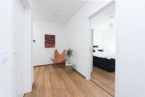 a living room with white walls and wooden floors at eifel5star - Burgfriedstraße in Daun