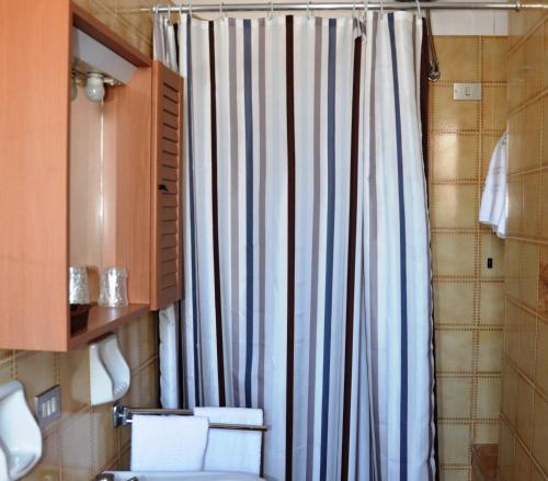 a bathroom with a shower curtain and a toilet at Hotel A-14 in Modugno