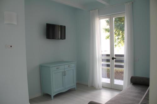 a room with a blue cabinet and a sliding glass door at Villa Carolina in Domaso