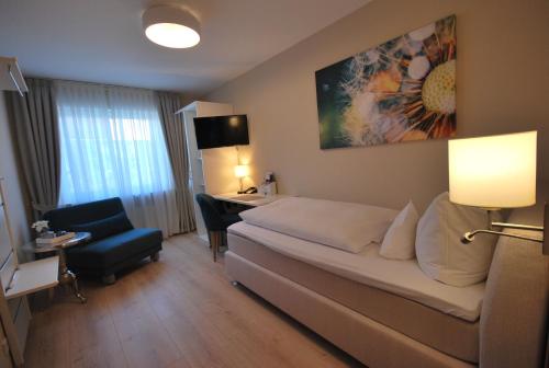 um quarto de hotel com uma cama e uma secretária em Hotel Colosseum em Rheinböllen