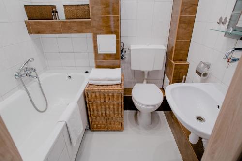 łazienka z wanną, toaletą i umywalką w obiekcie Prudentia Apartments Grenadierów w Warszawie