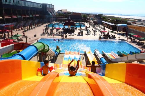 a large swimming pool with people in a water park at Spring Hotel in Novxanı