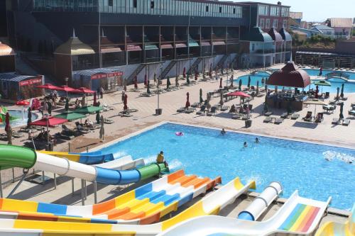 a large pool with a water park with people in it at Spring Hotel in Novxanı