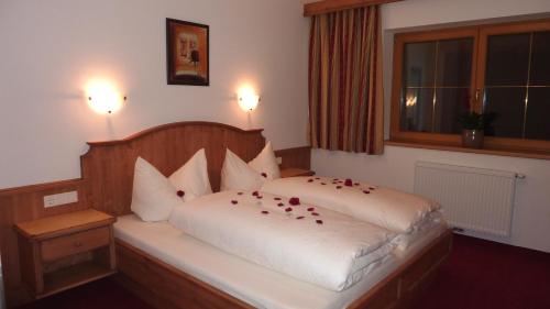 ein Schlafzimmer mit einem Bett mit roten Rosen darauf in der Unterkunft Ferienhof Nogler in Zellberg