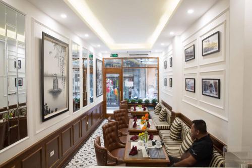 a man sitting at a table in a restaurant at Hanoi Amber Hotel in Hanoi