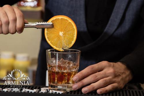 a person is squeezing an orange into a drink at Armenia in Nerkʼin Giratʼagh