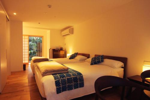 a bedroom with two beds and a window at Auberge AZABU in Kyoto