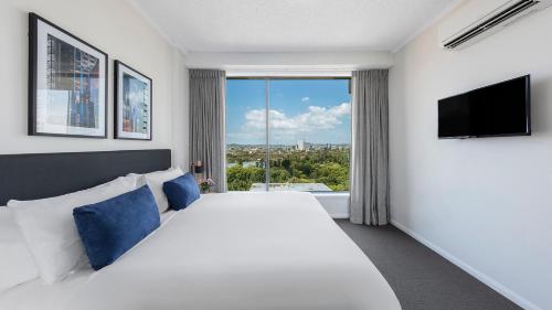 a hotel room with a bed and a window at Oaks Brisbane on Margaret Suites in Brisbane