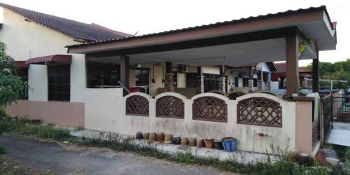 a house with a porch with potted plants on it at Zara Homestay in Machang