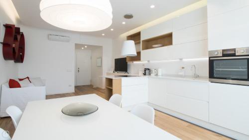 a white kitchen with a white table and chairs at Italianway - De Cristoforis 12 Flat in Milan