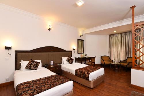 a hotel room with two beds and a desk at Park Village Resort by KGH Group in Kathmandu
