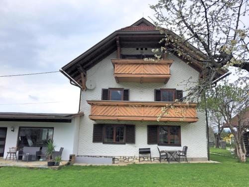 a house with a balcony on top of it at Parkweg Lodge in Faak am See