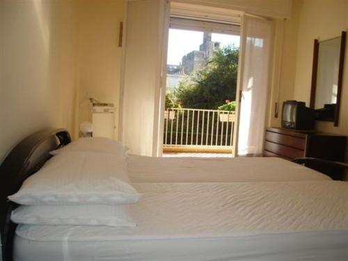 a white bed in a room with a window at Bordighera centro molto tranquillo in Bordighera