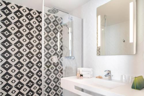 a bathroom with a sink and a mirror at Hotel des Lys in Versailles