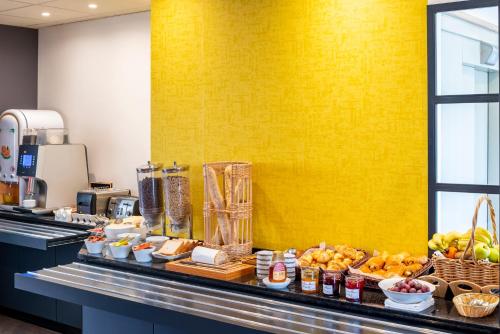 a buffet of food on a counter in a restaurant at Hotel des Lys in Versailles
