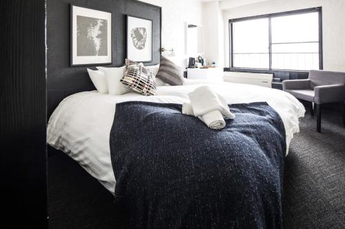 a bedroom with a large white bed with a window at Hotel Villa Hakuba by HHG in Hakuba