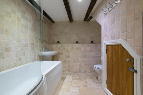 a bathroom with a tub and a sink and a toilet at The Moorings in St Ives