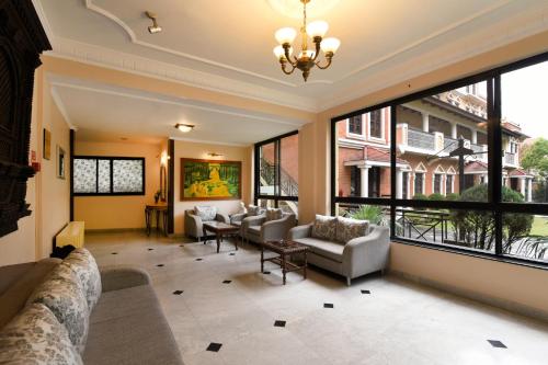 a living room with large windows and couches at Park Village Resort by KGH Group in Kathmandu