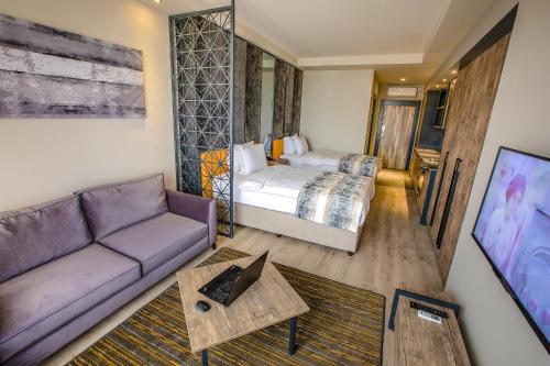 ein Wohnzimmer mit einem Sofa und einem Bett in der Unterkunft Shimall Hotel in Gaziantep