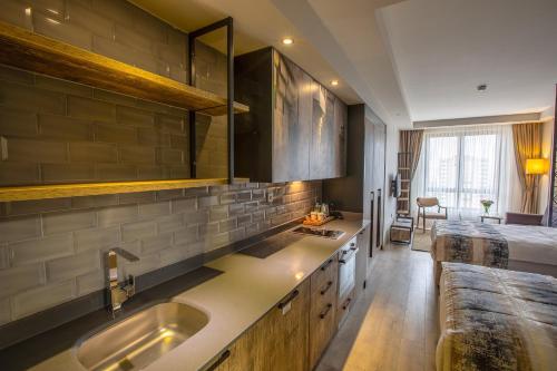 a kitchen with a sink and a bed in a room at Shimall Hotel in Gaziantep