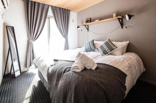 a bedroom with two beds and a window at Hotel Villa Hakuba by HHG in Hakuba