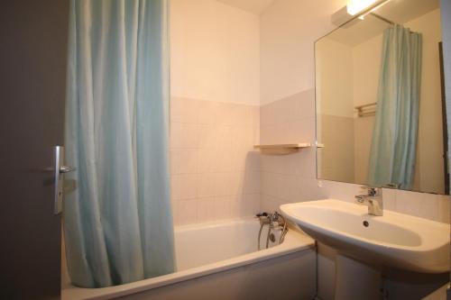 une salle de bain avec un lavabo et un rideau de douche dans l'établissement BEA122 - Appartement vue mer !, à Canet