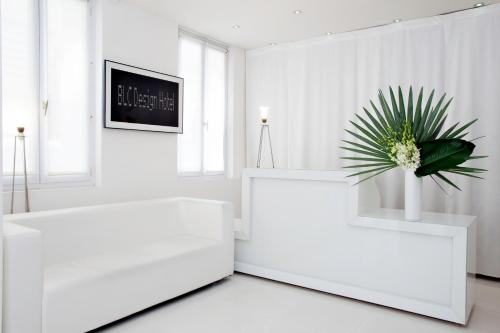a living room with white furniture and a potted plant at Blc Design Hotel in Paris
