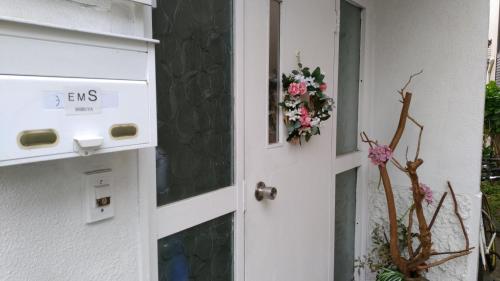 a white door with a flower wreath on it at EMS Enoshima クラシックゲストハウス 寝室は個室 犬OK in Fujisawa