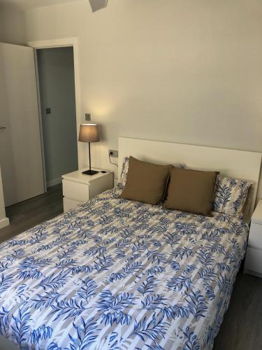 a bed with a blue and white comforter in a bedroom at MISTRAL 17 in El Campello