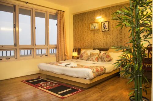 a bedroom with a bed and a large window at Jagjeet's Sikkim Retreat in Gangtok