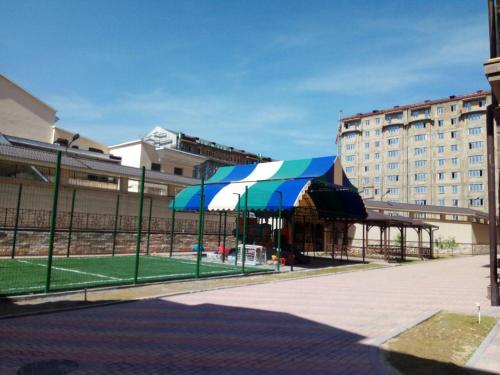 a pavilion with a blue and white umbrella next to a building at Apartments on Shevchenko in Tashkent