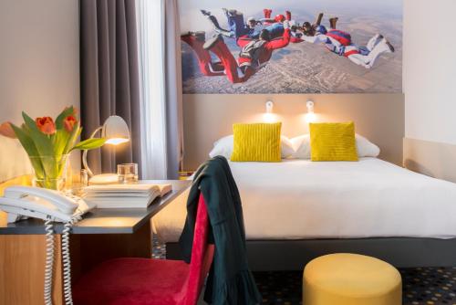 a hotel room with a bed and a desk at ibis Styles Warszawa West in Mory