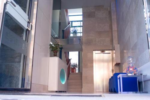 un pasillo con una escalera y una maleta azul en Hostal Acuarela, en Burgos