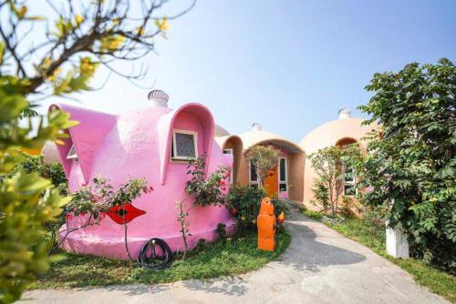 a pink house with a fire hydrant in front of it at Kenting Ha-Bi Star Fort in Hengchun