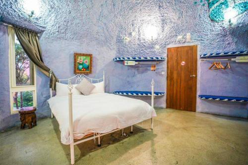 a bedroom with a bed in a blue room at Kenting Ha-Bi Star Fort in Hengchun