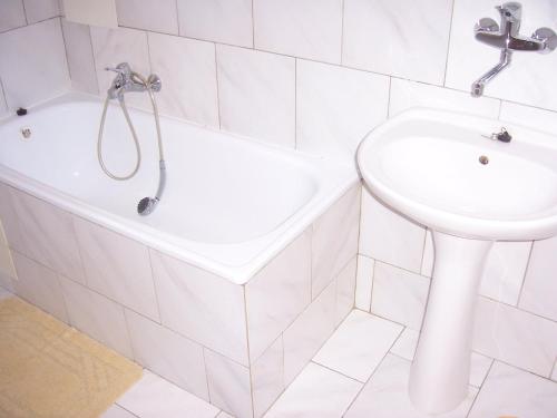 a bathroom with a sink and a tub and a toilet at Pension Baron in Vrchlabí