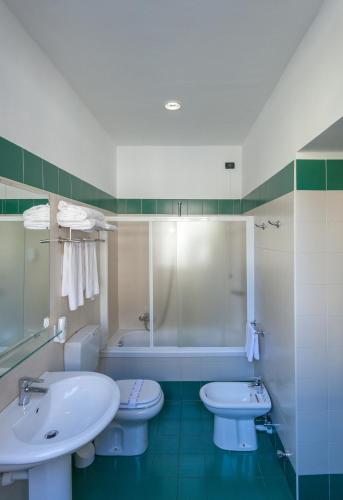 a bathroom with two toilets and a sink and a tub at Best Quality Hotel Dock Milano in Turin