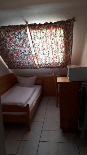 Cette petite chambre dispose d'une fenêtre avec un rideau. dans l'établissement Hotel Restaurant Anna, à Ramstein-Miesenbach