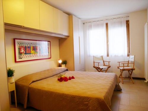 グラードにあるAppartamento La Cromaのベッドルーム1室(花の飾られたベッド1台付)