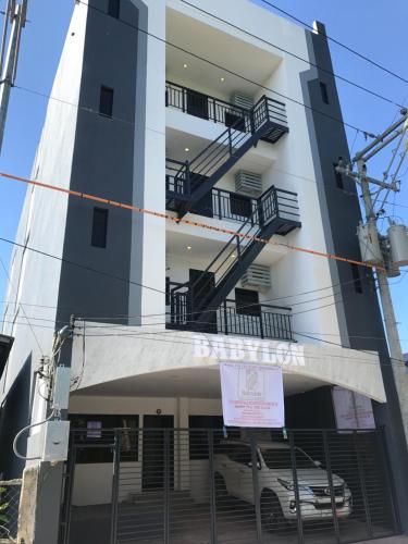a building with a car parked in front of it at Babylon Oslob Coast Guesthouse in Oslob