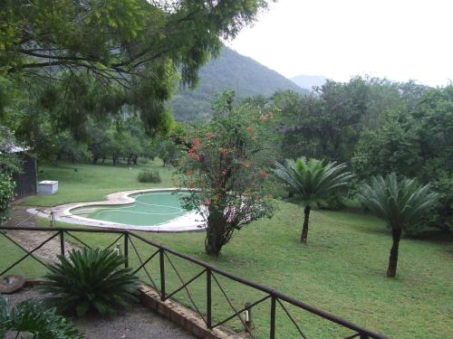 a swimming pool in a park with trees and a fence at Old Coach Road Guest House in Barberton