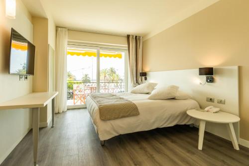 a bedroom with a large bed and a window at La Dolce Vita Hotel in Menton