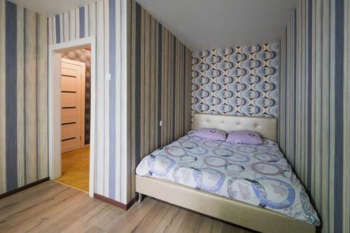 una camera da letto con un letto con cuscini viola di Apartment at Pervomayskaya a Mogilev