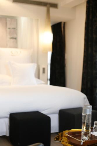 a bedroom with a bed and a table with a glass of water at Domaine de Verchant & Spa - Relais & Châteaux in Montpellier